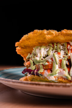 Crispy patacon with cabbage slaw and creamy sauce on plate, fried plantain latin street food concept, selective focus