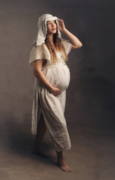 Artistic Full Body Portrait of Pregnant Woman in Medieval White Gown