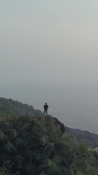 Vertical Aerial View of Man Standing on Cliff at Apsarakonda Coast Karnataka India