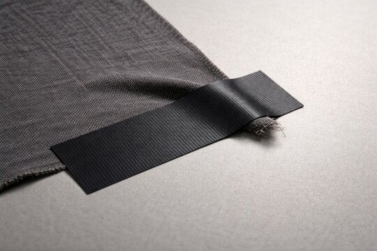 Piece of gaffer tape holding fabric on blank flat surface