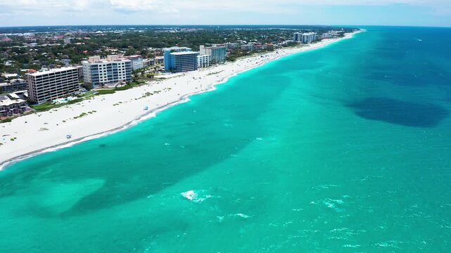 High-rise buildings line a sandy shoreline adjacent to teal ocean waters. Ideal for real estate marketing or travel promotions.