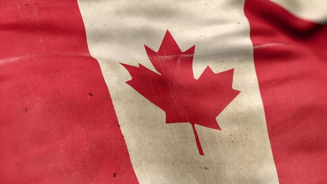 A Canada flag, made of old cloth, dirty and stained, flutters in the wind. A Worn Canadian Flag Waves In The Breeze.