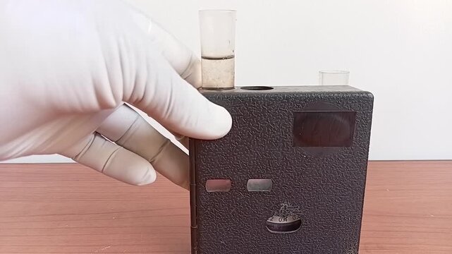 Technician Inserting Colored And Clear Water Sample Cells Into A Chlorine Comparator For Residual Chlorine Testing