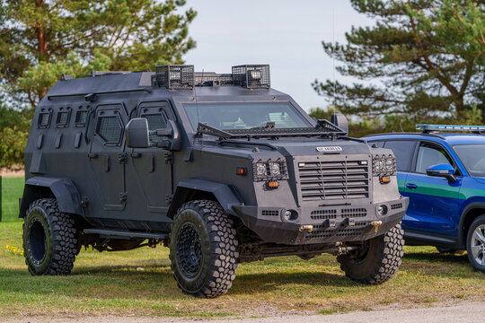 IAG Guardian tactical armored vehicle in matte black parked outdoors, heavy-duty military armored personnel carrier for security and law enforcement missions
