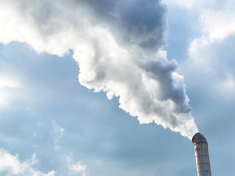 Large white smoke plume from industrial factory chimney stack