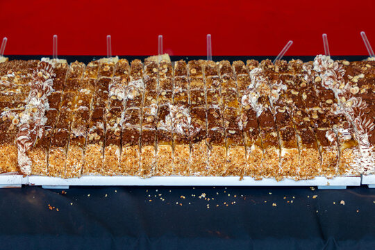 Cut pieces of chocolate cake with cracked nuts on a tray