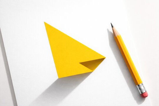 Yellow graphic with shadow alongside wooden pencil on clean white paper minimal design