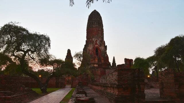 Timerlapse Wat Phra Ram ancient ruins in Ayutthaya Historical Park, Thailand, featuring a towering central prang and weathered brick walls during a serene sunrise timelapse