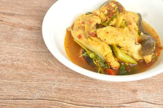 spicy fried Asian redtail catfish with herb and chili on bowl