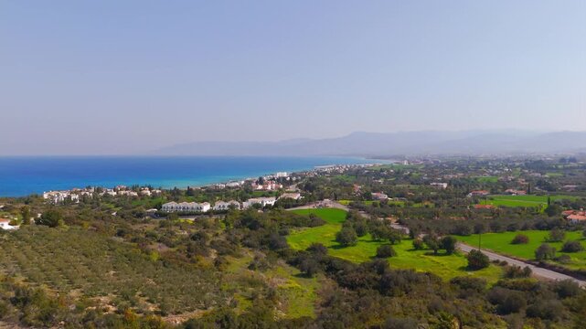 Aerial Drone Flyover of Lush Green Fields Towards Latsi Coast and Blue Mediterranean Sea in Cyprus