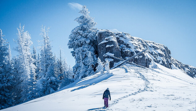 Rear view of a Woman in skiwear hiking to the top of a mountain, Vail, Colorado, USA