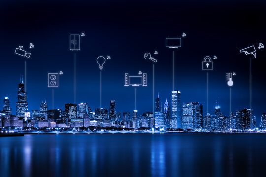 Icons depicting the Internet of Things above a smart city skyline at night, Chicago, Illinois, USA