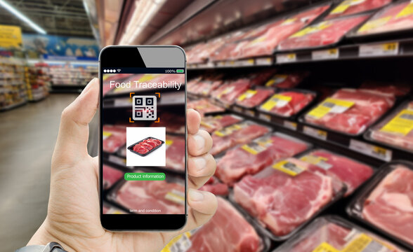 Food safety traceability system concept. Man hand using mobile phone scanning QR code in supermarket