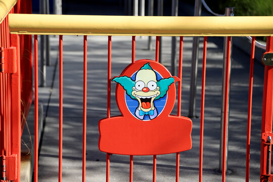 Krusty the Clown poster on a red theme park fence with copy space