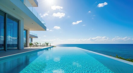 Obraz premium A modern luxury villa features a crystal clear infinity pool that blends seamlessly into the vast blue ocean under a bright sunny sky, sunny, serene, peaceful