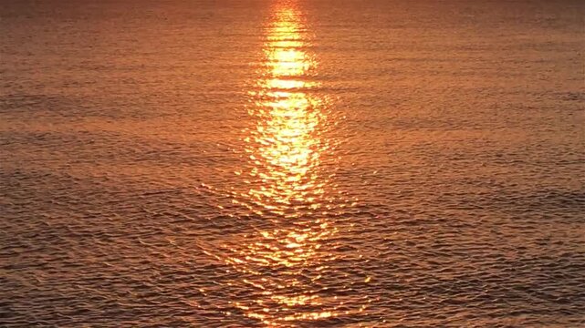 Vast Golden Ocean Surface with Deep Orange Sunset Reflection