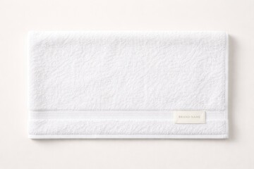 Fototapeta premium Plain background featuring a horizontal layout of a white terry towel with brand label for design use