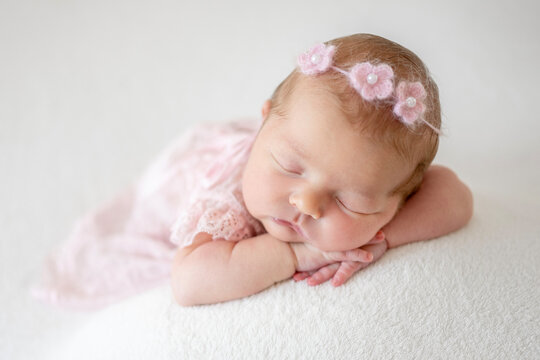 Photoshoot Of A Newborn Girl Sleeping On A White Blanket
