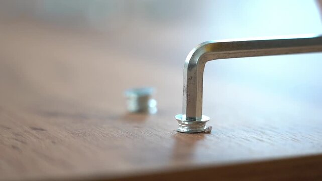installing furniture fittings with a hex key close-up. furniture assembly. High quality FullHD footage