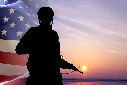 Silhouette of a soldier with USA flag against the sunset. Memorial Day, Veterans Day