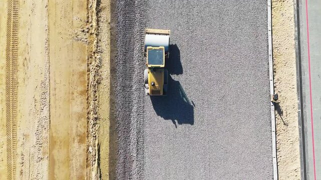 Road construction roller view from the top. catog rams the rubble on the road,Supports the construction of modern roads using heavy construction equipment. High quality 4k footage