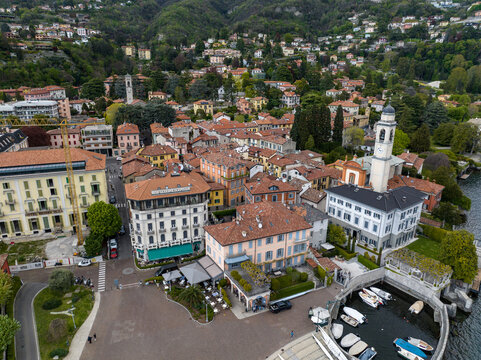 Aerial view of the historic town center featuring the San Vincenzo church tower, colorful buildings, and a small harbor on Lake Como, Cernobbio, Lombardia, Italy.