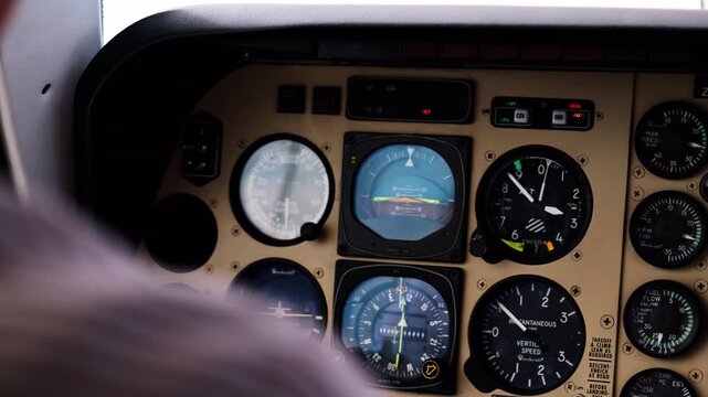 Close-up of airplane cockpit dashboard showing analog flight instruments, gauges, and controls. Ideal for aviation, pilot training, travel, and technology visuals inside an aircraft cabin.