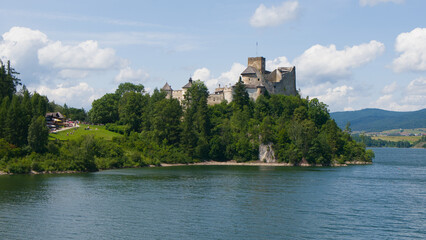 Obraz premium Medieval Niedzica Castle by Czorsztyn Lake, historic fortress in Pieniny Mountains, Poland.