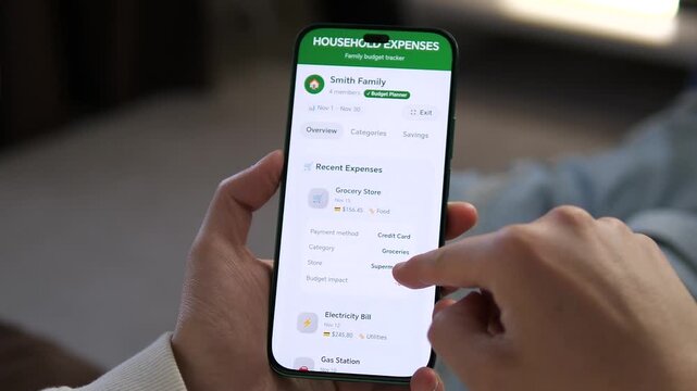 Tracking the cost of living at home. A family budget planner app displays energy bills, fuel prices, and savings goals. Great for documentaries on inflation, economy, and modern digital lifestyle