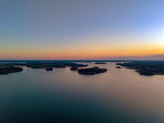 Obraz premium Top-down aerial view of small boats at a wooden pier on the rocky coast of Turku Archipelago