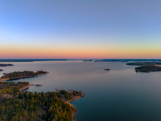 Fototapeta premium Top-down aerial view of small boats at a wooden pier on the rocky coast of Turku Archipelago