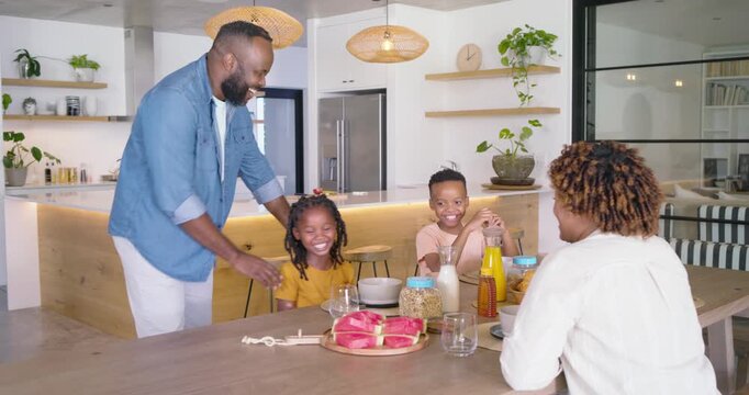 African American family seeing dad walking with watermelon tray, serving, patting, leaving at table