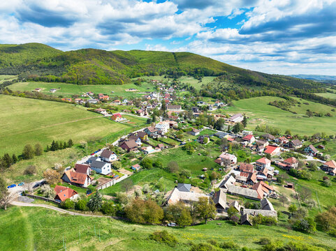 Aerial view of the gren lush forest and expansive fields with village Podzamcok in Slovakia