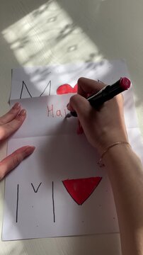 Vertical top view video of writing the word &ldquo;Happy&rdquo; on a postcard with a marker, handwritten process on a white background, creative DIY style.
