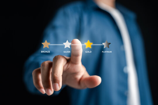 Loyalty rewards program tiers for customer membership. Man pointing at stars for bronze silver gold and platinum status achievement and business marketing strategy.