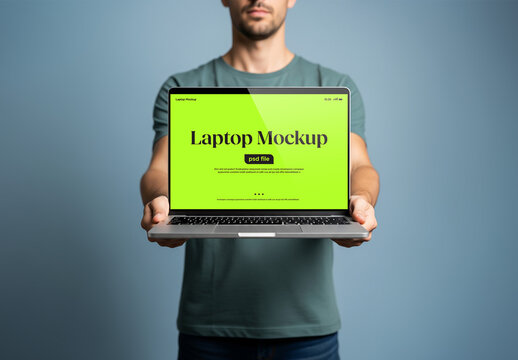 A man holding a laptop in front of him for a mockup