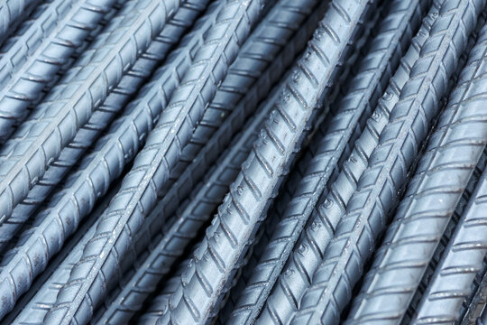 Close up detailed view of strong solid steel rebar construction material showing heavy iron metal texture piled securely for reliable building foundation strength