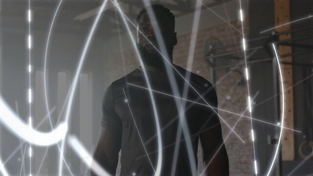 Male trainer standing in gym, projected LED starting, sweeping light obscuring then revealing form