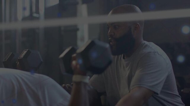 On trainee starting press trainer spotting hex dumbbells in fitness gym animated HUD showing form