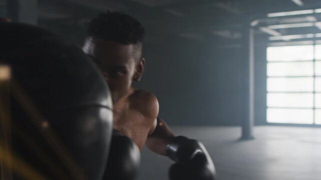 Boxer hitting heavy bag in industrial gym, strikes activating golden network overlay for power