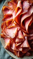 Fototapeta premium Thinly Sliced Cured Ham Arranged Artfully on a Rustic Plate. A close-up view of thinly sliced, cured ham, showcasing its rich color and delicate texture, presented on a textured ceramic plate
