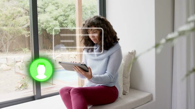 Mature woman window bench holding tablet, green icon glowing, UI moving, tapping to reply in tech