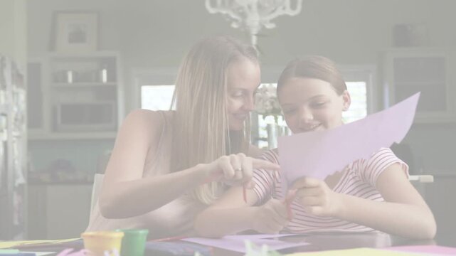 Mother pointing and guiding, daughter cutting purple paper with scissors for learning craft