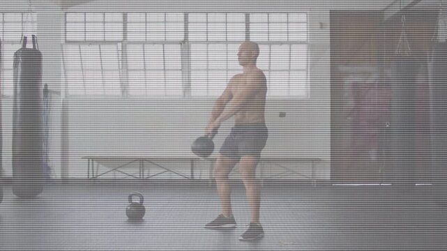 Man stepping to kettlebell and gripping handle, performing explosive swings and presses for fitness
