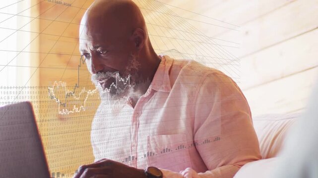 Senior man leaning toward laptop as animated finance charts rising, typing and reacting with glee