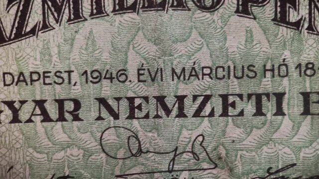 Macro video showing the design detail of a vintage Hungarian 100 million pengo banknote issued in 1946. The footage highlights the denomination text, decorative typography, and fine printed patterns.