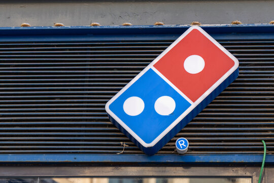Valencia, Spain - 29 October 2025: Dominos Pizza logo is shown outside a restaurant in an urban area.