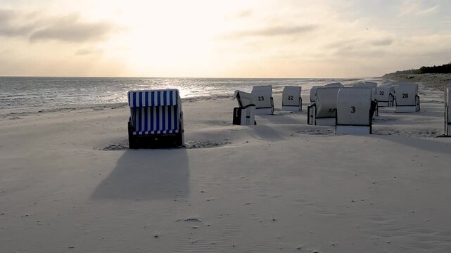 Empty beach chairs are bathed in the light of the rising sun on the beach at the Baltic resort of Prerow on the Darss (Vorpommern Bodden Landscape National Park).