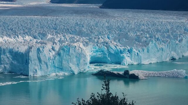 View over the vast Perito Moreno Glacier in Los Glaciares National Park, Argentina, showcasing striking white and blue ice formations meeting the waters of Lago Argentino in a dramatic landscape