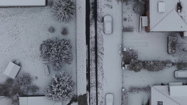 Snow-covered suburban district in Berlin from straight-down drone view.
Houses and cars lining quiet winter streets.